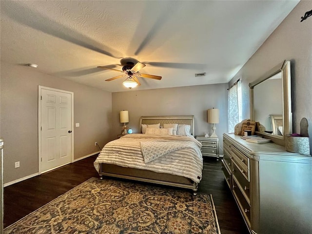 bedroom featuring dark wood-style floors, ceiling fan, and baseboards