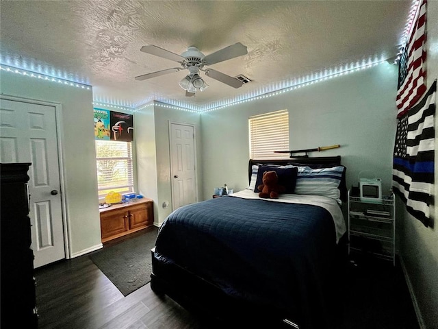 bedroom with wood finished floors, a textured ceiling, and ceiling fan