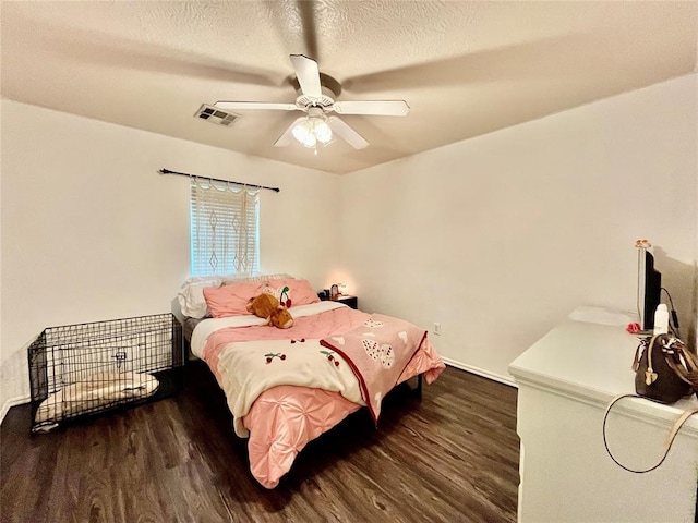 bedroom with wood finished floors, ceiling fan, and a textured ceiling