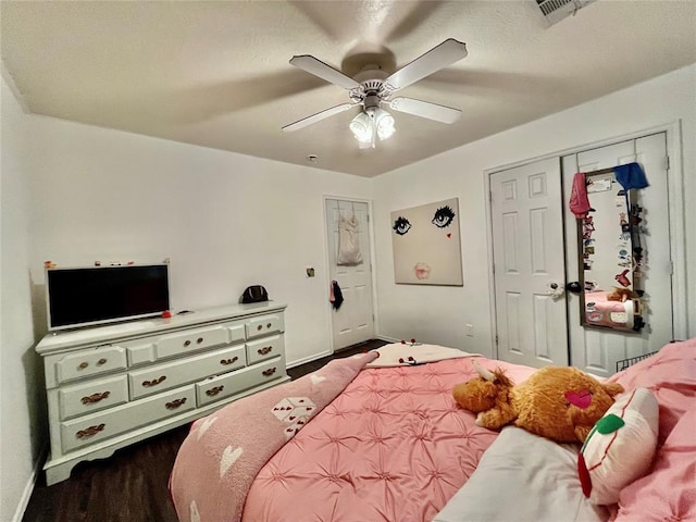 bedroom with a ceiling fan, baseboards, and dark wood-type flooring