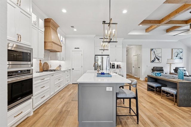 16309 Rangeland Dr, Oklahoma City, OK 73170 - kitchen with appliances with stainless steel finishes, custom range hood, open floor plan, a kitchen breakfast bar, and light countertops