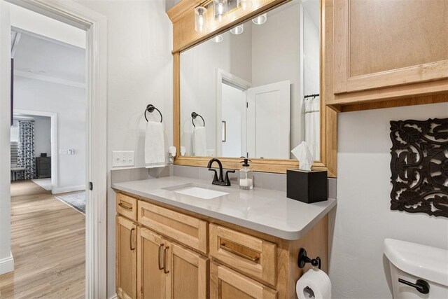 16309 Rangeland Dr, Oklahoma City, OK 73170 - bathroom featuring toilet, wood finished floors, vanity, baseboards, and ornamental molding