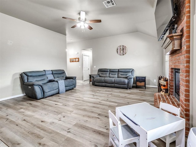 living area with ceiling fan, baseboards, light wood-style floors, and a brick fireplace