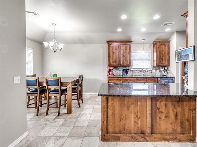 kitchen featuring a sink, baseboards, plenty of natural light, a chandelier, and recessed lighting