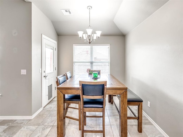 dining space featuring a chandelier, lofted ceiling, and baseboards