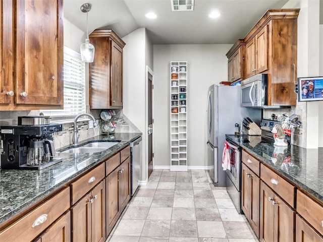 kitchen with stainless steel appliances, a sink, brown cabinetry, and recessed lighting