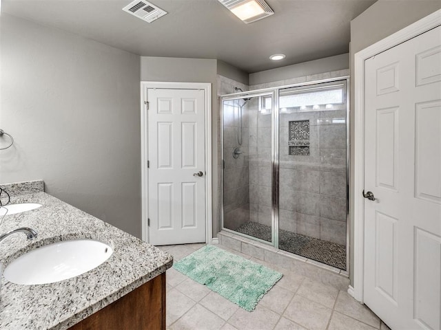 full bathroom with a stall shower, tile patterned flooring, and double vanity