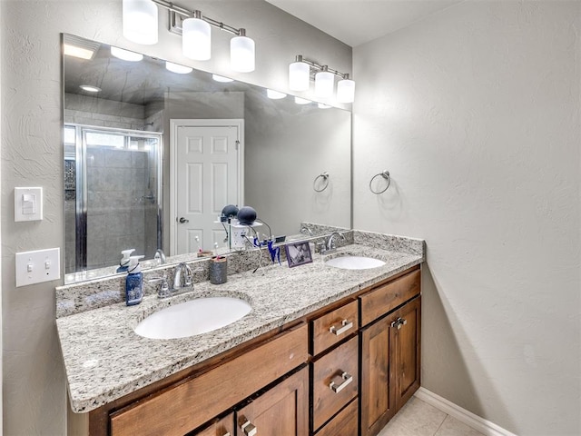 full bath featuring a shower stall, double vanity, tile patterned floors, and a textured wall