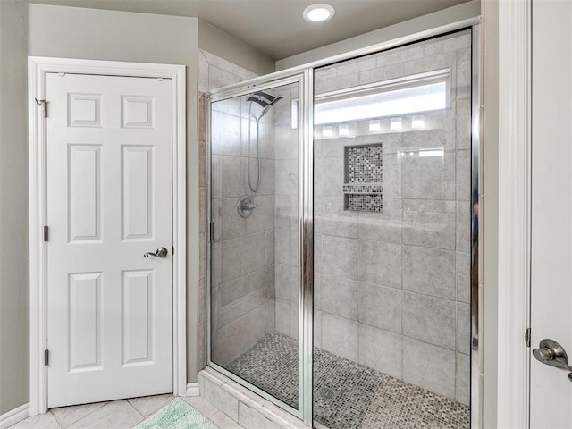 bathroom with a shower stall and tile patterned flooring