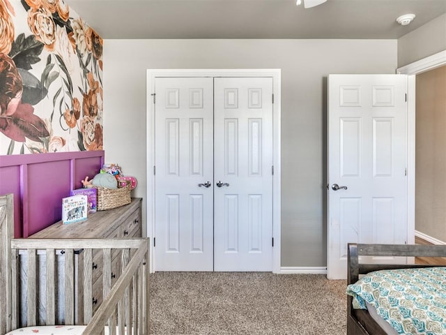carpeted bedroom featuring a closet and baseboards
