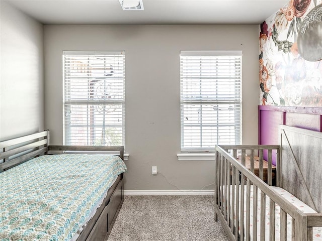 carpeted bedroom with baseboards and multiple windows