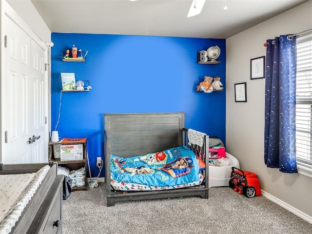 carpeted bedroom with multiple windows, baseboards, a closet, and ceiling fan