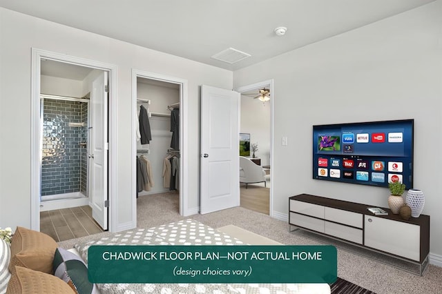 bedroom with a spacious closet, ensuite bathroom, a closet, and baseboards