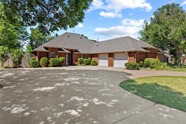 2001 Saber Ln, Weatherford, OK 73096 - view of front of house featuring brick siding, a garage, concrete driveway, and a shingled roof