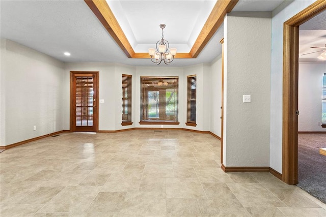 2001 Saber Ln, Weatherford, OK 73096 - entryway featuring baseboards, a chandelier, a textured wall, and a tray ceiling