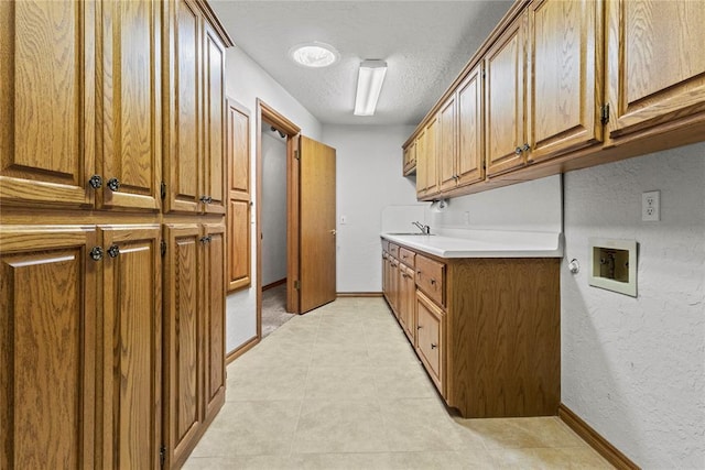 2001 Saber Ln, Weatherford, OK 73096 - washroom featuring cabinet space, hookup for a washing machine, a textured ceiling, baseboards, and a textured wall