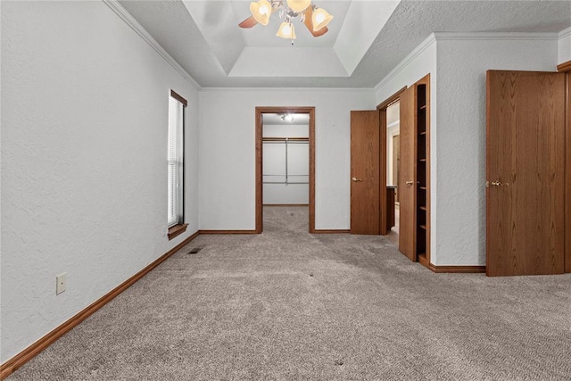 2001 Saber Ln, Weatherford, OK 73096 - unfurnished bedroom featuring a textured wall, carpet floors, crown molding, a walk in closet, and ceiling fan