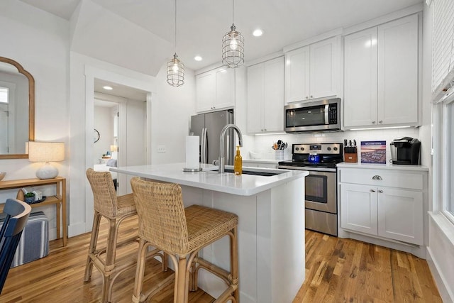 43 Center Ln, Carlton Landing, OK 74432 - kitchen featuring appliances with stainless steel finishes, a sink, recessed lighting, an island with sink, and light wood-style floors