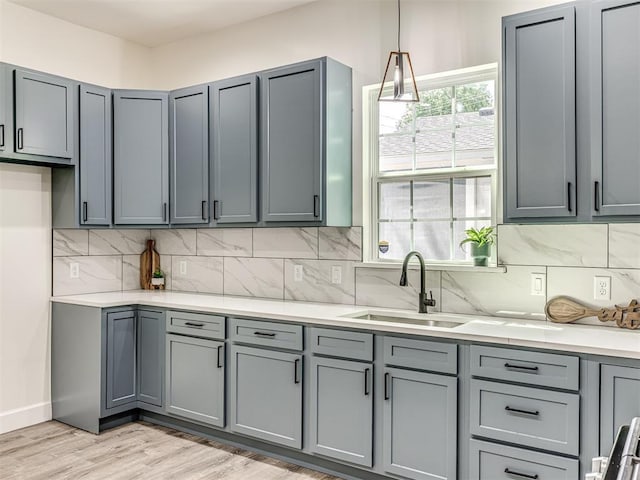 1800 NW 41st St, Oklahoma City, OK 73118 - kitchen with gray cabinets, a sink, light countertops, and decorative backsplash