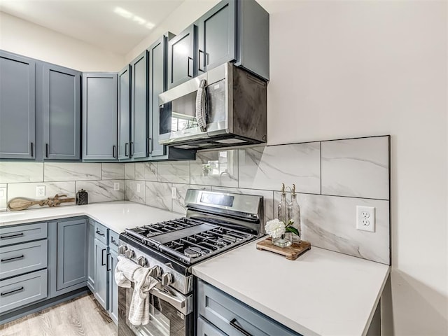 1800 NW 41st St, Oklahoma City, OK 73118 - kitchen featuring stainless steel appliances, backsplash, light countertops, and gray cabinetry