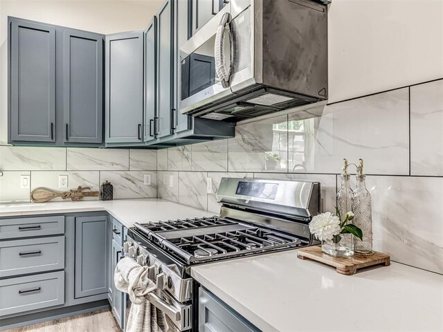 1800 NW 41st St, Oklahoma City, OK 73118 - kitchen with stainless steel appliances, gray cabinetry, decorative backsplash, and light countertops