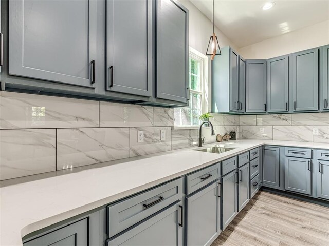 1800 NW 41st St, Oklahoma City, OK 73118 - kitchen featuring a sink, hanging light fixtures, backsplash, and light wood-type flooring