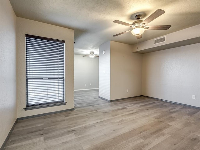 11530 N May Ave Unit D303, Oklahoma City, OK 73120 - spare room featuring ceiling fan, baseboards, wood finished floors, and a textured ceiling