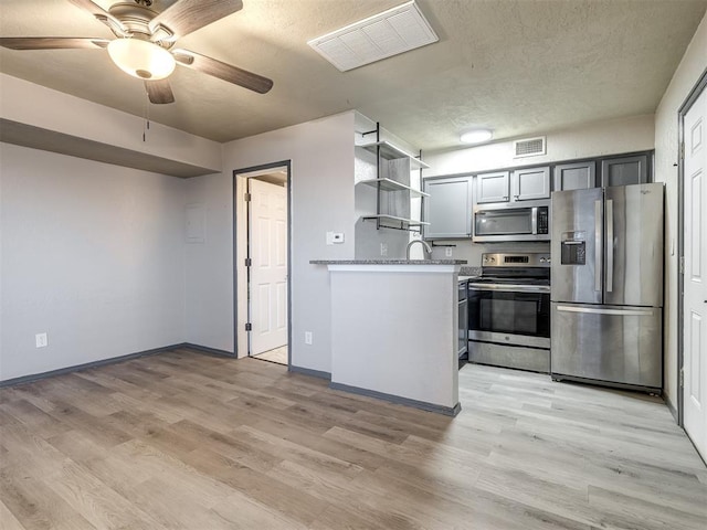 11530 N May Ave Unit D303, Oklahoma City, OK 73120 - kitchen featuring stainless steel appliances, open shelves, a ceiling fan, baseboards, and a textured ceiling