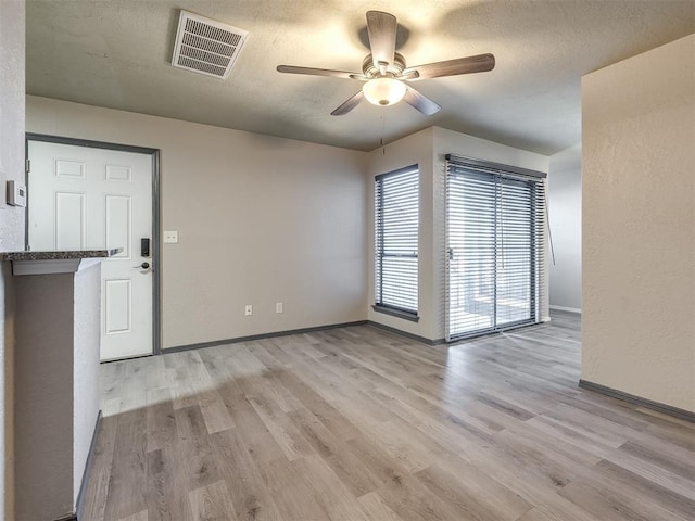 11530 N May Ave Unit D303, Oklahoma City, OK 73120 - empty room featuring ceiling fan, a textured ceiling, baseboards, and light wood-type flooring