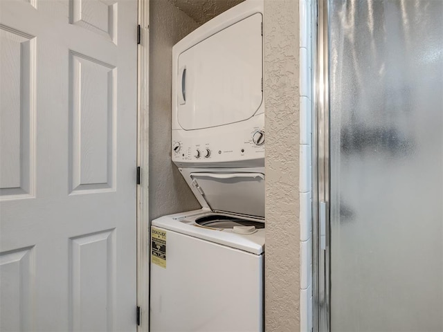 11530 N May Ave Unit D303, Oklahoma City, OK 73120 - laundry area with stacked washer / dryer and a textured wall