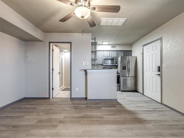 11530 N May Ave Unit D303, Oklahoma City, OK 73120 - kitchen featuring appliances with stainless steel finishes, light wood-style floors, ceiling fan, light countertops, and electric panel