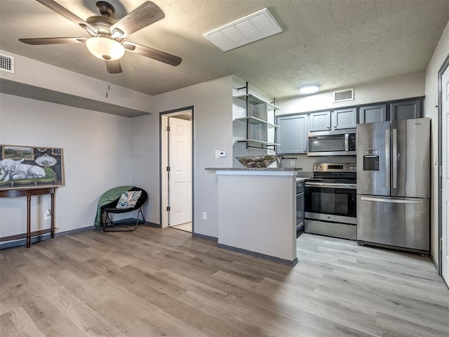 11530 N May Ave Unit D303, Oklahoma City, OK 73120 - kitchen with stainless steel appliances, light wood-style floors, ceiling fan, open shelves, and a textured ceiling