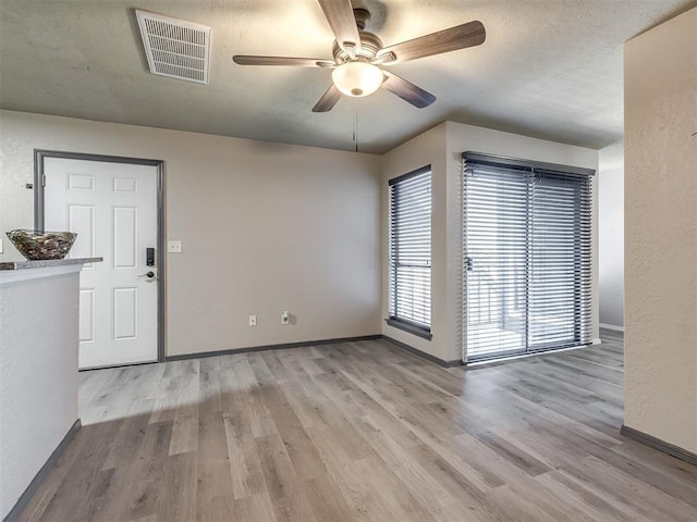 11530 N May Ave Unit D303, Oklahoma City, OK 73120 - unfurnished room featuring a ceiling fan, wood finished floors, a textured ceiling, and a textured wall
