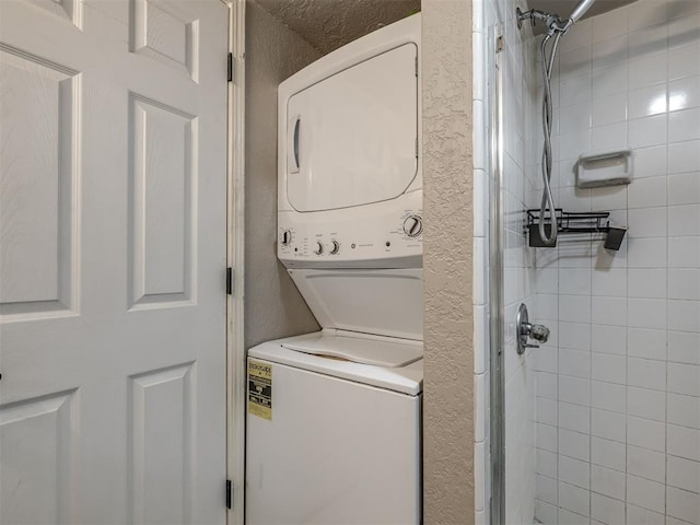 11530 N May Ave Unit D303, Oklahoma City, OK 73120 - laundry area featuring estacked washer and dryer and a textured wall