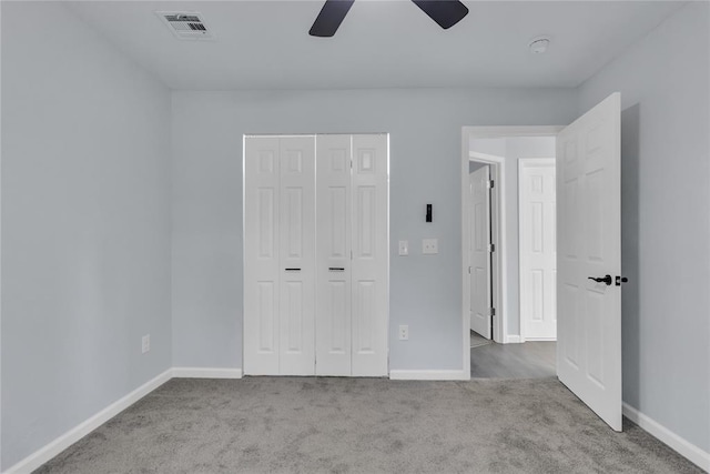 unfurnished bedroom with carpet floors, baseboards, a closet, and a ceiling fan