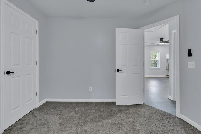 carpeted empty room featuring baseboards and ceiling fan