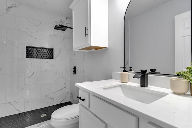 bathroom featuring tiled shower, vanity, toilet, and marble look tiles