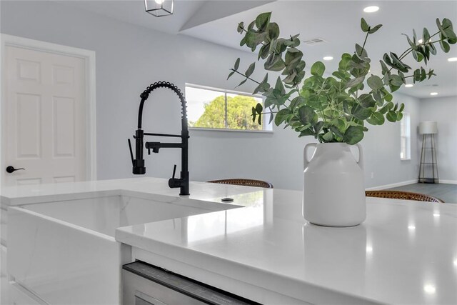 kitchen view of a sink, baseboards, and recessed lighting