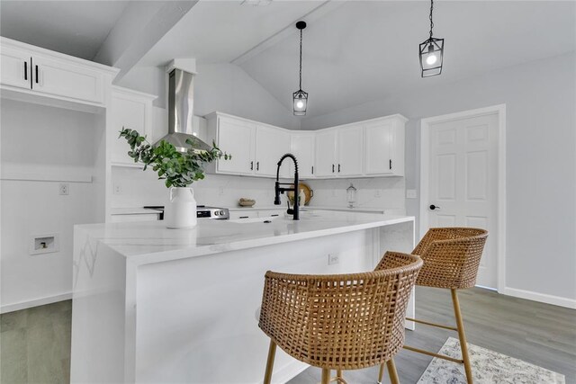 kitchen featuring ventilation hood, light wood-style floors, white cabinets, decorative light fixtures, and tasteful backsplash