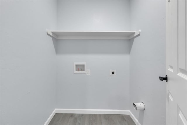 laundry area with electric dryer hookup, hookup for a washing machine, wood finished floors, and baseboards