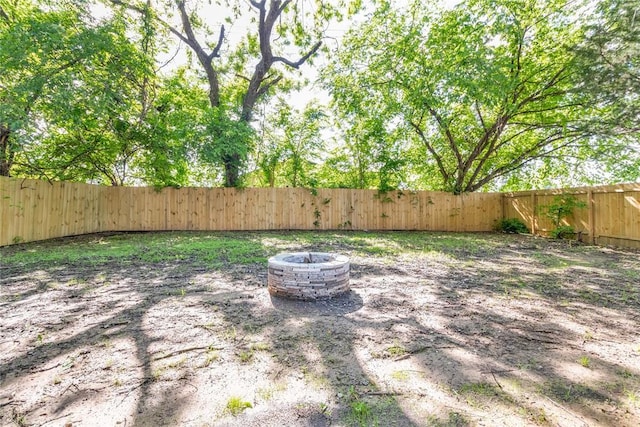 fenced backyard featuring a fire pit