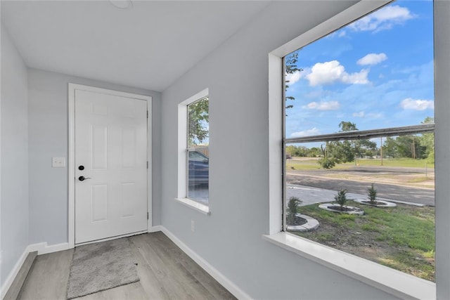 doorway featuring wood finished floors and baseboards
