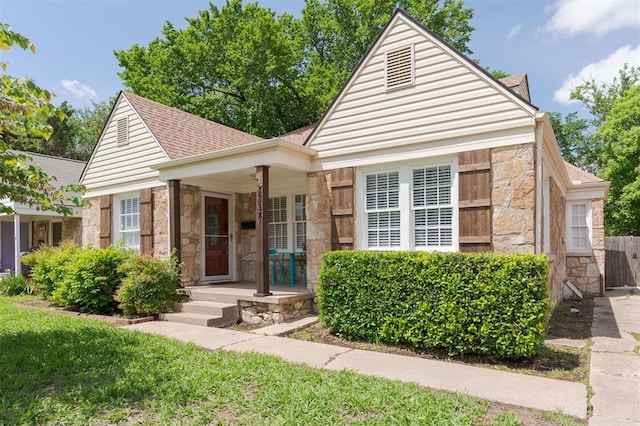 2237 NW 30th St, Oklahoma City, OK 73112 - bungalow-style house featuring stone siding, a shingled roof, and covered porch
