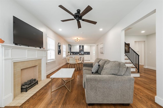 2237 NW 30th St, Oklahoma City, OK 73112 - living room with ceiling fan, stairs, wood finished floors, a tile fireplace, and recessed lighting