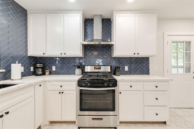 2237 NW 30th St, Oklahoma City, OK 73112 - kitchen featuring stainless steel gas stove, wall chimney range hood, decorative backsplash, and white cabinets