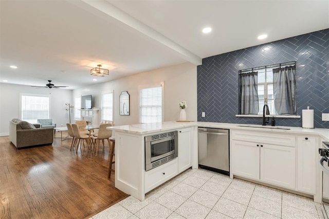 2237 NW 30th St, Oklahoma City, OK 73112 - kitchen with stainless steel appliances, a sink, healthy amount of natural light, white cabinets, and recessed lighting