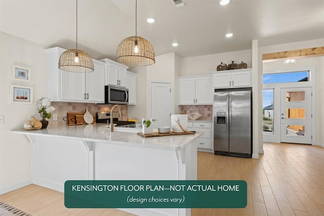 24119 Western Ave, Washington, OK 73093 - kitchen featuring appliances with stainless steel finishes, a peninsula, white cabinets, light wood finished floors, and tasteful backsplash