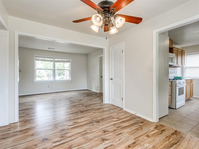 1829 Westchester Dr, Oklahoma City, OK 73120 - empty room with a ceiling fan, light wood-type flooring, and baseboards