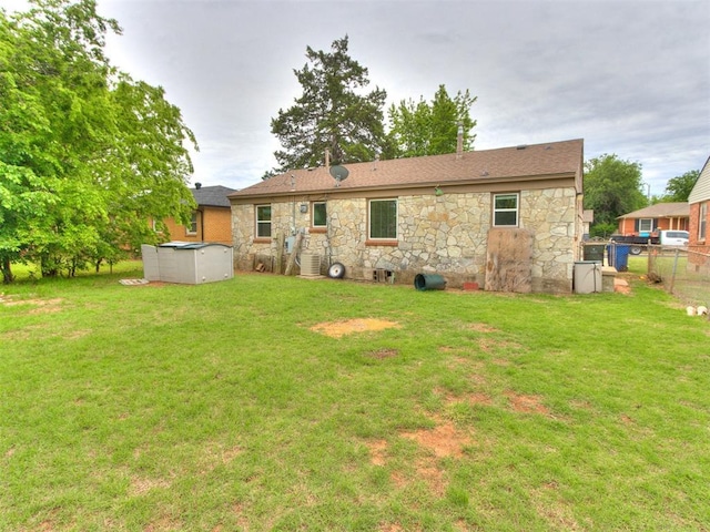 1829 Westchester Dr, Oklahoma City, OK 73120 - back of house with stone siding, an outdoor pool, and central AC unit