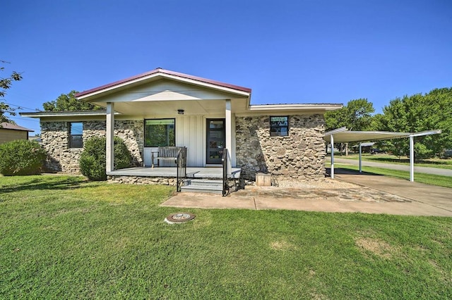 519 N J St, Eufaula, OK 74432 - view of front of home with a porch, a front lawn, a detached carport, and stone siding